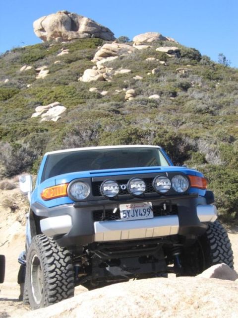 2007 Toyota FJ Cruiser - A blue 2007 Toyota FJ Cruiser navigates a rocky, off-road trail under a clear blue sky.