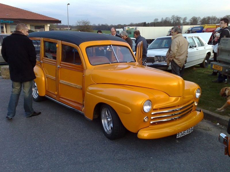Orange woody wagon with a black roof, chrome grille, and custom wheels. License plate reads 9345 XG64