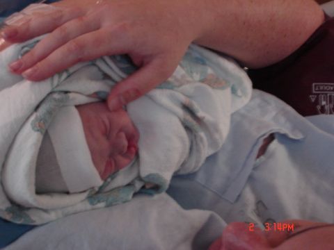 1981 Ford Bronco - A close-up view of a newborn baby being held by an adult's hand.