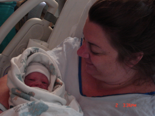 Newborn baby in blanket with woman