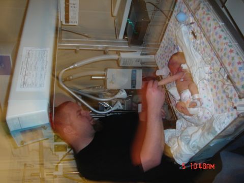 1981 Ford Bronco - A father interacts with his newborn baby in a hospital incubator, surrounded by medical equipment.
