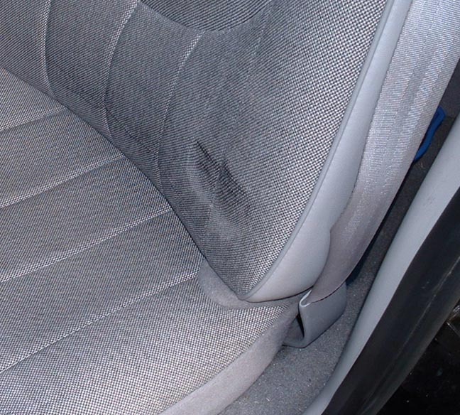 Gray fabric seat interior with a stain on the cushion