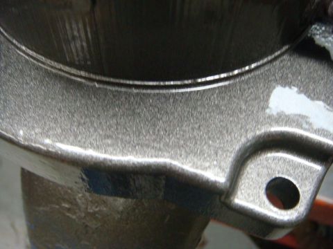 1996 Ford Bronco - Close-up of a painted metal component, likely a vehicle part, with a textured surface.