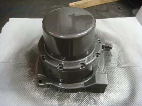 1996 Ford Bronco - A metallic winch component sits on a textured surface, showing signs of recent painting.