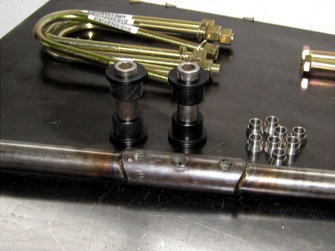 1996 Ford Bronco - Collection of automotive suspension components and hardware laid out on a dark surface.