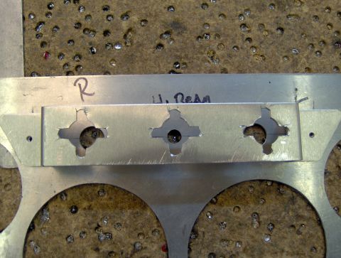 1978 Ford Bronco - A metal bracket with unique cutouts and handwritten markings is shown up close.