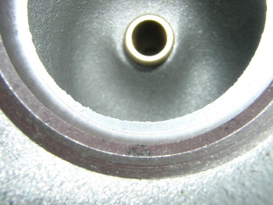 Close-up of a metal engine part with a brass insert