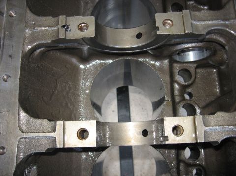 1978 Ford Bronco - Close-up inside a bare engine block's main bearing valley, showing freshly machined main bearing saddles and caps with clean bolt holes and…