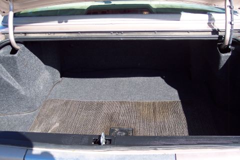 2001 Ford Crown Victoria - The interior of a car trunk is shown, revealing grey carpeting and a textured mat.