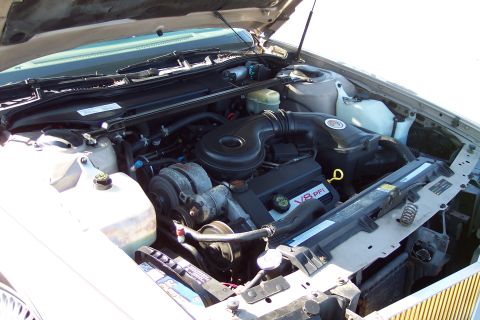 2001 Ford Crown Victoria - The engine bay of a vehicle is shown, a V8 PFI badge on the engine cover.