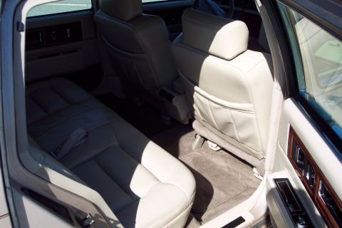 2001 Ford Crown Victoria - The spacious interior features beige leather seats and elegant wood trim, offering a glimpse into the car's cabin.
