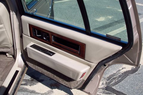 2001 Ford Crown Victoria - Interior view of a car door panel with wood trim and beige upholstery.