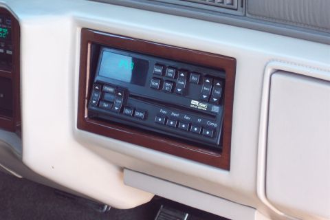 2001 Ford Crown Victoria - Close-up of a car's dashboard, focusing on the stereo system with wood trim and a digital display.
