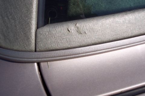 2001 Ford Crown Victoria - Torn fabric on a convertible top is visible near the window seal.