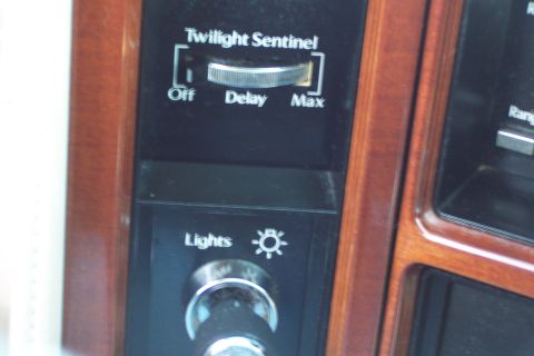 2001 Ford Crown Victoria - Close-up of a car's interior dashboard controls, including a lights switch and a dial for 'Twilight Sentinel'.