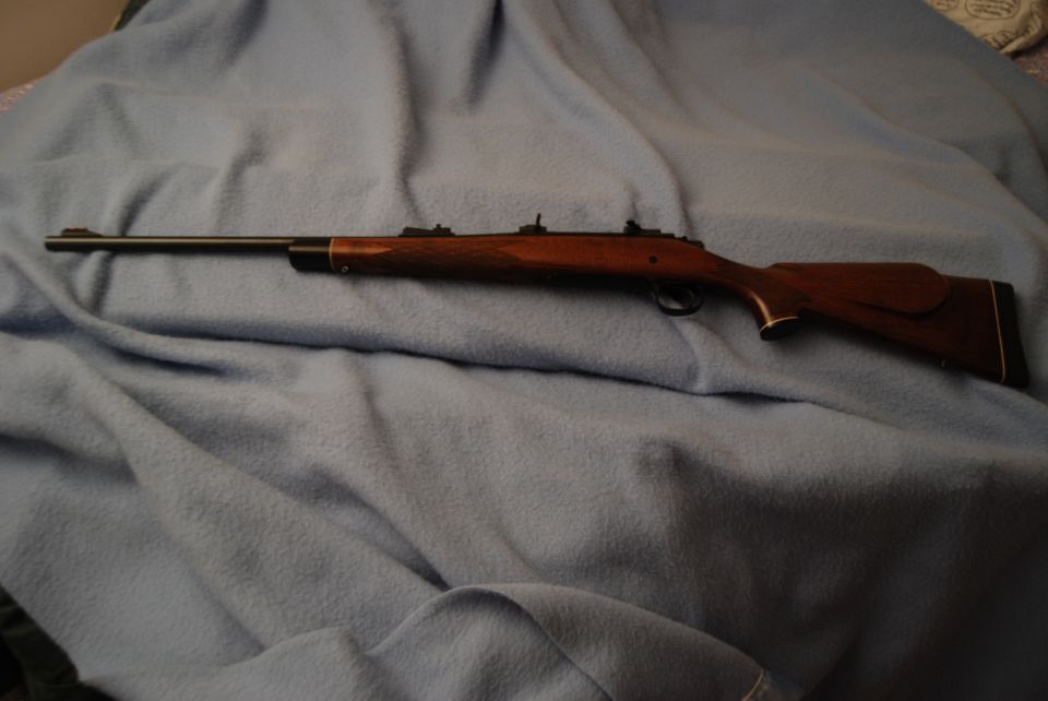 Wooden rifle with a long barrel resting on a blue blanket