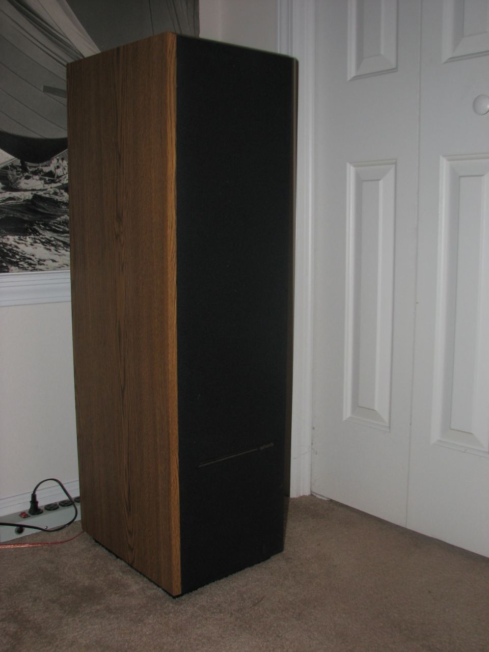 Tall wooden and black home stereo speaker