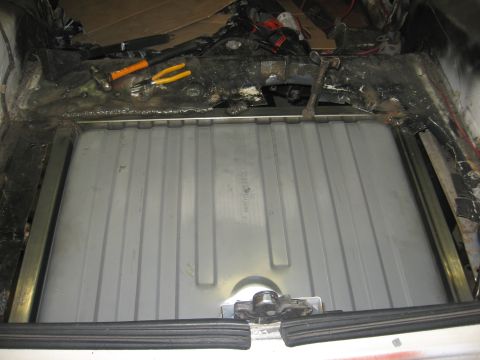 1978 Ford Mustang II - A new gas tank is installed in the trunk of a car, with tools visible on the surrounding metal.
