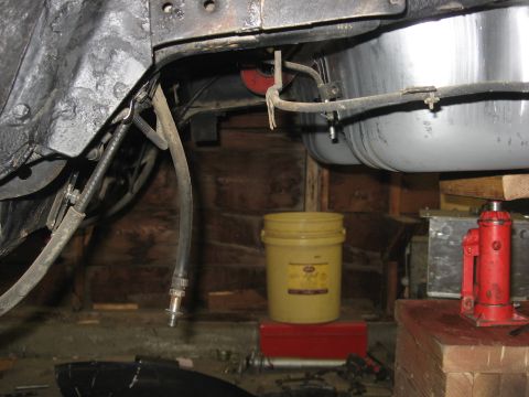 1978 Ford Mustang II - The underside of a vehicle is shown with a gas tank and fuel lines, suggesting maintenance or repair work.