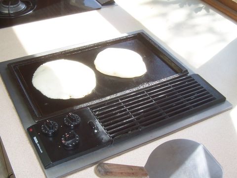 1994 Ford F-150 - Electric griddle cooking pancakes on a countertop, with a spatula nearby.