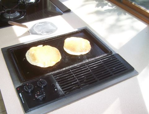 1994 Ford F-150 - Pancakes are being cooked on a griddle, with a spatula and stovetop visible.