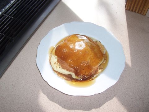 1994 Ford F-150 - A plate of pancakes covered in syrup sits on a counter next to a grill.