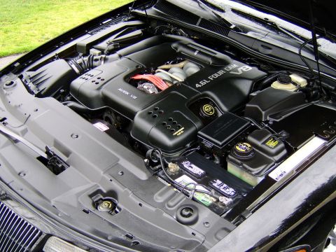 1996 Mercury Grand Marquis - The engine bay features a 4.6L Four Cam V8 engine, prominently displayed with its black cover and visible battery.