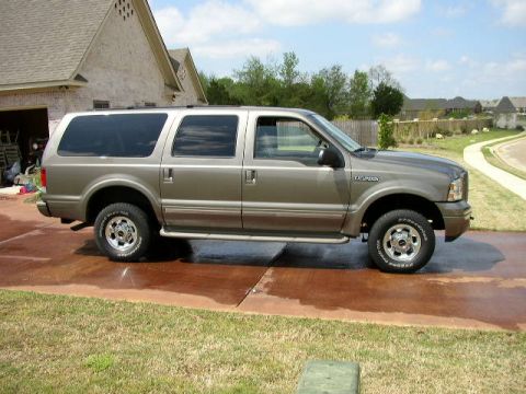 1995 Ford Bronco - This Ford Excursion is parked in front of a house on a sunny day.