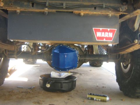 1986 Ford Bronco - A vehicle's rear differential and fuel tank are shown, with a drain pan positioned below.