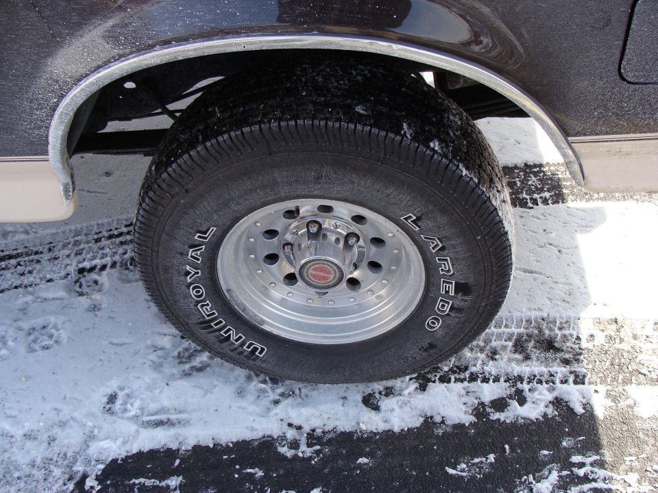 1992 Ford Bronco rear wheel with Uniroyal Laredo tire and chrome trim on fender