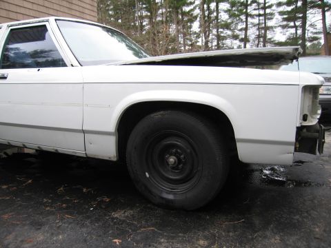 1991 Ford LTD Crown Victoria - A white sedan, possibly a 1990 model, is shown with its hood ajar and front end damaged.