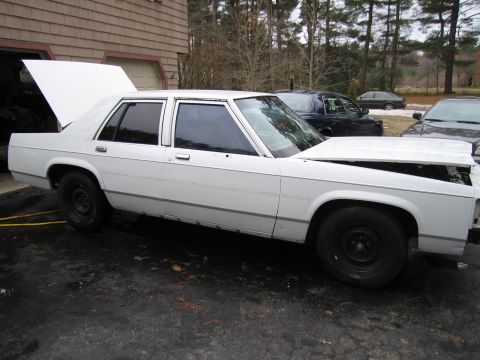 1991 Ford LTD Crown Victoria - This 1991 Ford Crown Victoria LTD sedan is shown with its hood and trunk open, revealing its engine bay and cargo space.