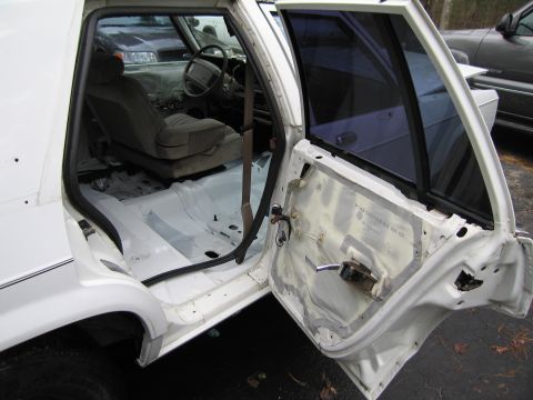 1991 Ford LTD Crown Victoria - The interior of a 1991 Ford Crown Victoria LTD shows signs of disassembly, with the rear passenger door open.