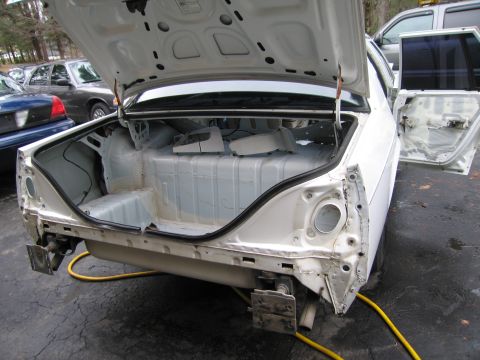 1991 Ford LTD Crown Victoria - Rear view of a 1991 Ford Crown Victoria LTD undergoing disassembly, with trunk and door open.