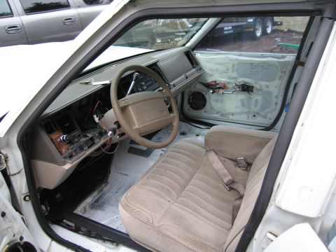 1991 Ford LTD Crown Victoria - The interior of a car is shown with the door panels removed, revealing exposed wiring and the dashboard.