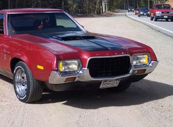 1971 Ford Ranchero - Red 1971 Ford Ranchero driving on a road with other vehicles in the background.