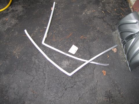 1991 Ford LTD Crown Victoria - Chrome trim pieces and a car fender are scattered on the ground.