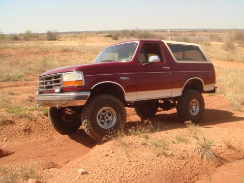 1992 Ford Bronco - This 1992 Ford Bronco is shown off-roading on a dusty trail under a clear blue sky.