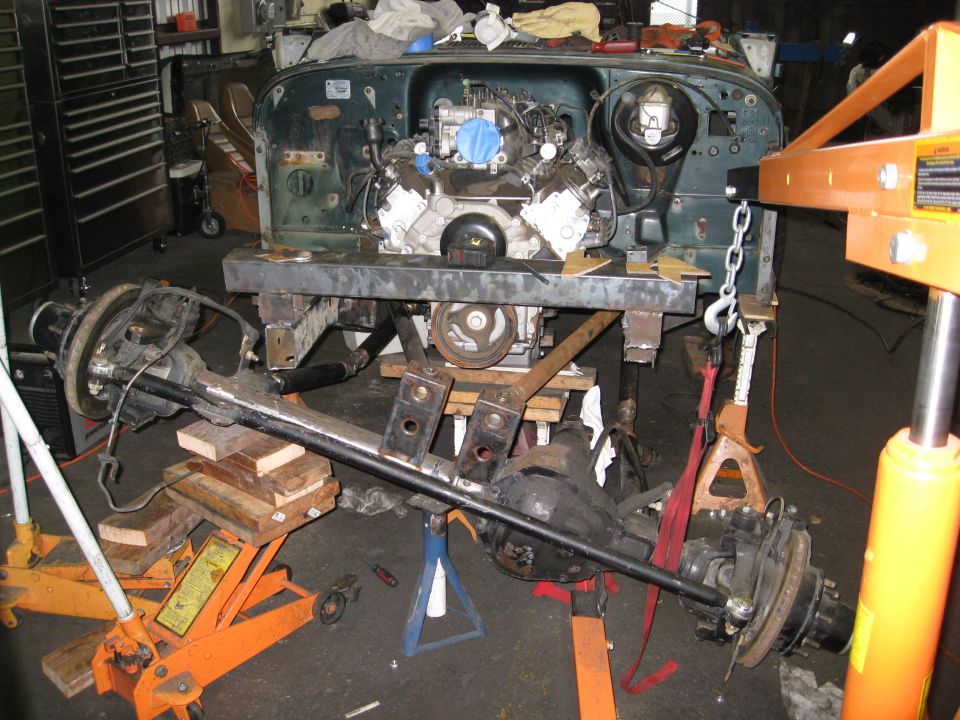Jeep YJ chassis on jack stands with engine and axles removed, undergoing repair