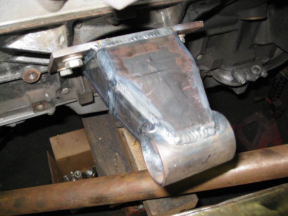 Custom bracket on vehicle transmission, Supermotors.net logo visible