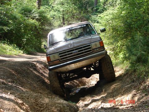 1987 Ford Bronco - This 1987 Ford Bronco tackles a challenging muddy trail with its tires angled.