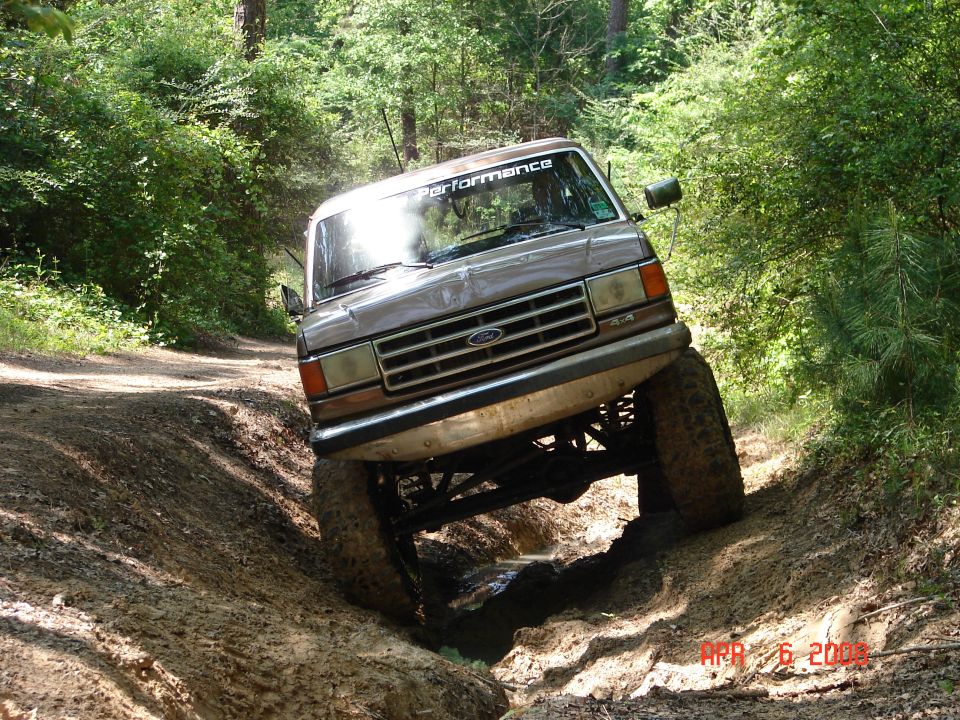 1987 Ford Bronco off-roading on a dirt path