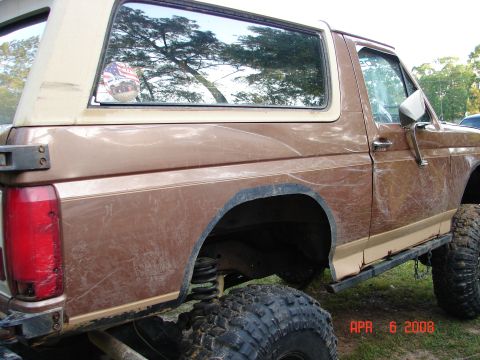 1987 Ford Bronco - This 1987 Ford Bronco is shown from the side, large off-road tires and a two-tone brown paint scheme.