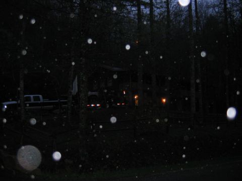 1992 Ford Mustang - A dark pickup truck is visible on the left side of the frame, parked near a house with lights on, during a dark, possibly rainy night.