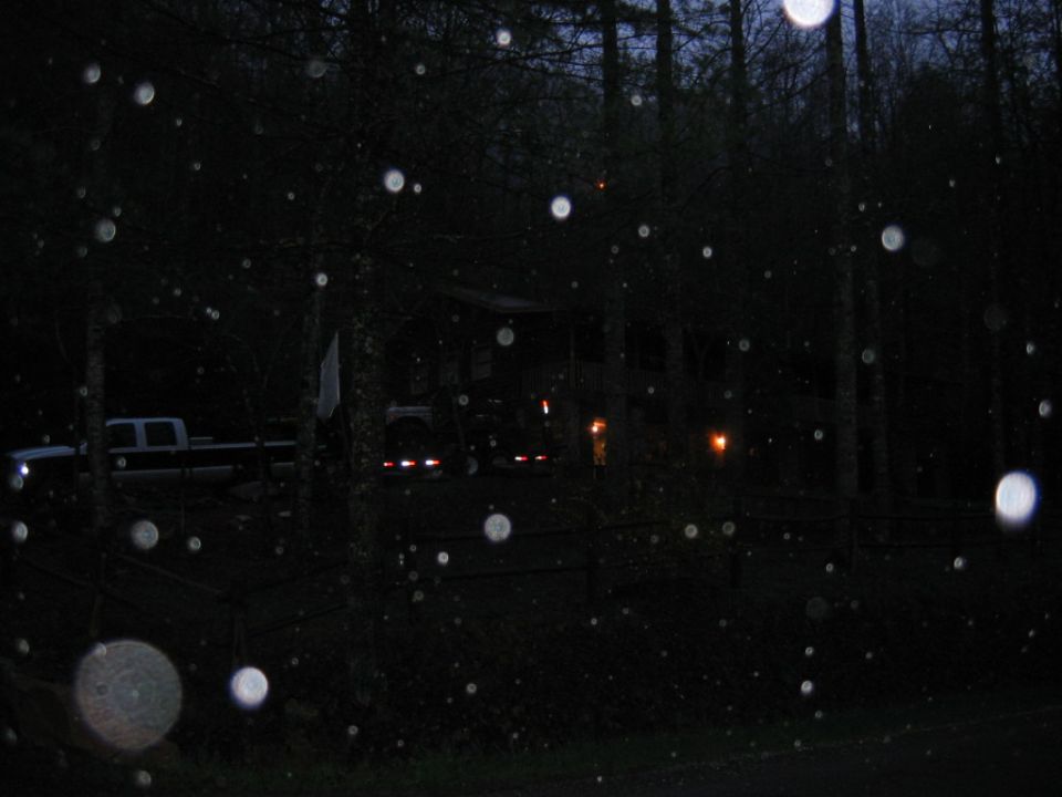 Side view of a dark pickup truck parked near a house at night