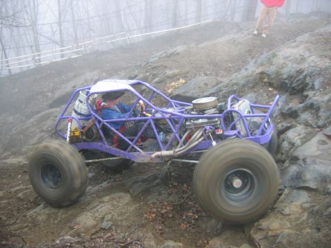 1992 Ford Mustang - A custom purple buggy navigates a challenging rocky terrain on a foggy day.