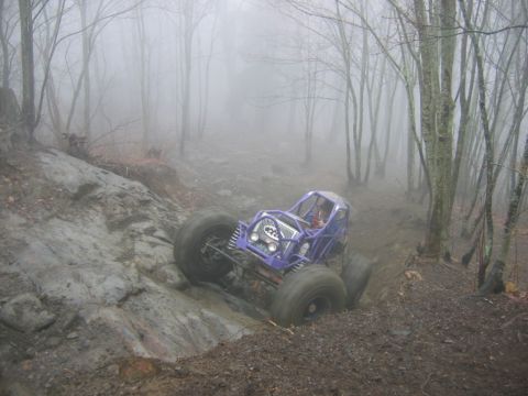 1992 Ford Mustang - A custom off-road buggy tackles a challenging muddy trail amidst a misty woodland.