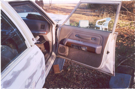 1991 Ford Crown Victoria - The interior of a car is shown with the driver's side door open, revealing the door panel and dashboard.