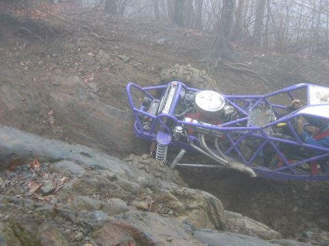1992 Ford Mustang - A custom-built purple buggy navigates a rocky, off-road trail on a foggy day.
