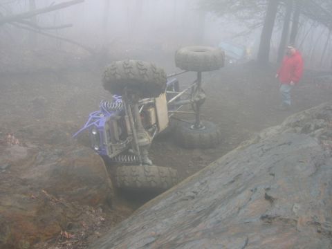 1992 Ford Mustang - An off-road buggy has overturned in a challenging, foggy terrain, with another vehicle in the distance.